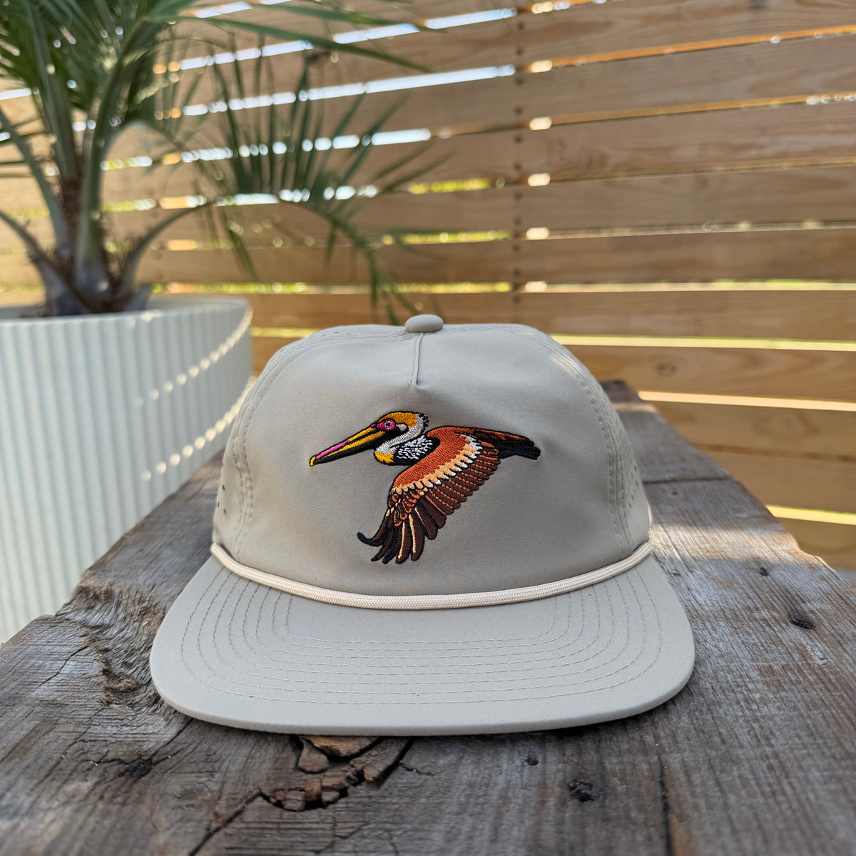 Salt SQD Coastal Reserve Cap in Brown Pelican, front view showing pelican logo and rope brim
