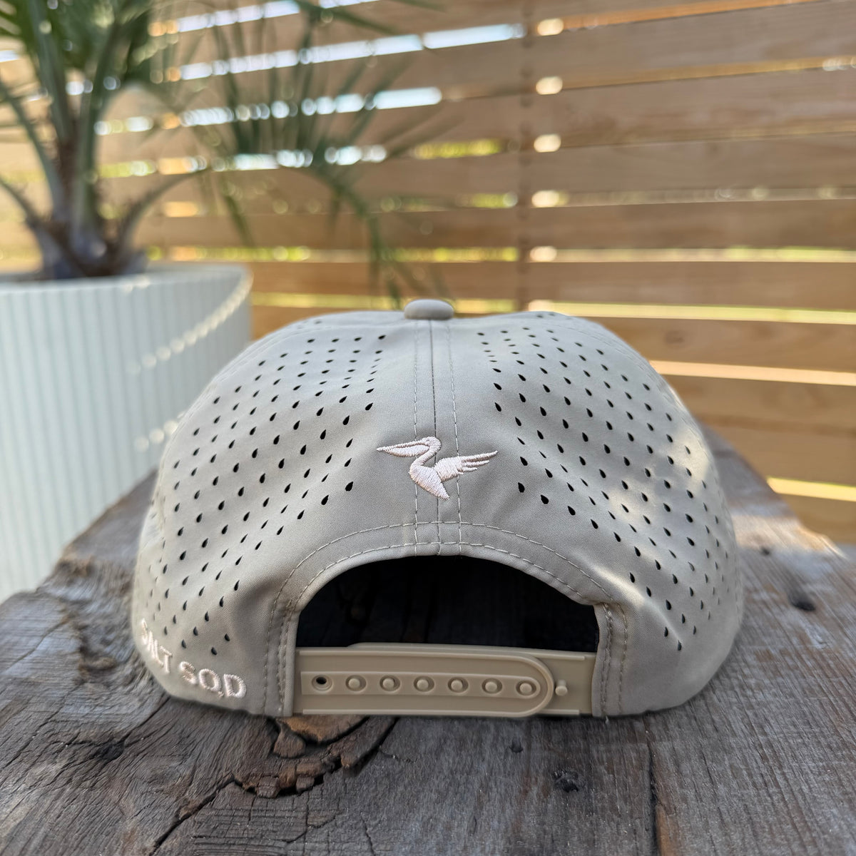 Salt SQD Coastal Reserve Cap in Brown Pelican, rear view showing perforated panels, snapback closure, and Salt SQD branding